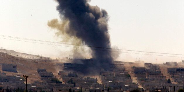 Smoke rises after a shell lands in Kobani in Syria as fighting intensifies between Syrian Kurds and the militants of Islamic State group, as seen from the outskirts of Suruc, at the Turkey-Syria border, Monday, Oct. 6, 2014. Kobani, also known as Ayn Arab and its surrounding areas have been under attack since mid-September, with militants capturing dozens of nearby Kurdish villages. (AP Photo/Lefteris Pitarakis)