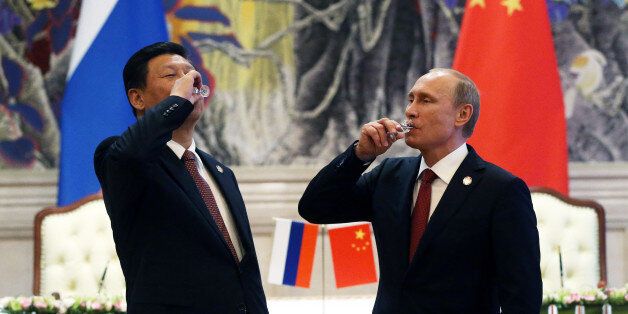 SHANGHAI, CHINA - MAY 21: President of Russia Vladimir Putin and Chinese President Xi Jinping toast with vodka during a signing ceremony on May 21, 2014 in Shanghai, China. Russia and China signed a thirty-year contract for supply of gas. (Photo by Sasha Mordovets/Getty Images)