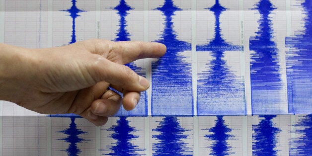 Taiwan's Central Weather Bureau official Lu Pei-ling points to seismograph readings of a 6.7 magnitude earthquake that shook Taiwan, Tuesday, Dec. 26, 2006, in Taipei, Taiwan. The quake, with a preliminary magnitude of between 6.7 and 7.2, was felt throughout Taiwan. It swayed buildings and knocked objects off the shelves in the capital, Taipei. No damage or injuries were immediately reported. (AP Photo)