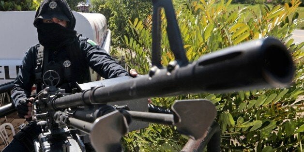 A federal police officer mans a general-purpose machine gun (GPMG) at a checkpoint in Iguala, Guerrero State, Mexico, on October 7, 2014. Mexican federal forces disarmed the southern city's entire police corps and took over security Monday after officers were accused of colluding with a gang in violence that left 43 students missing. AFP PHOTO/Pedro PARDO (Photo credit should read Pedro PARDO/AFP/Getty Images)