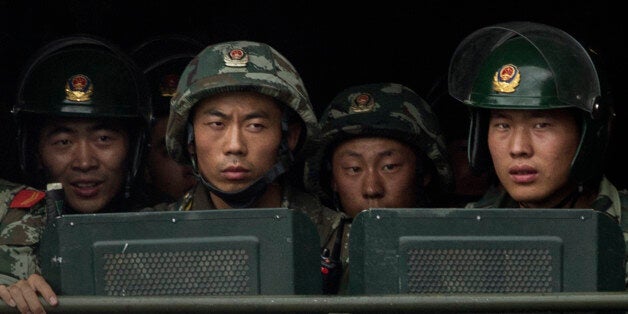 KASHGAR, CHINA - JULY 31: Chinese soldiers ride on the back of a truck as they patrol outside the Id Kah Mosque, China's largest, on July 31, 2014 in Kashgar, China. China has increased security in many parts of the restive Xinjiang Uyghur Autonomous Region following some of the worst violence in months in the Uyghur dominated area. (Photo by Getty Images)