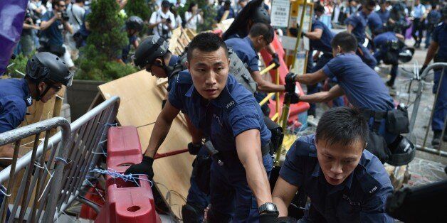 Police officers remove barricades during a pro-democracy protest in the Admiralty district of Hong Kong on October 14, 2014. Dozens of police removed barricades from a second Hong Kong protest site, a day after a similar attempt at the city's main occupied area largely backfired as demonstrators rebuilt and reinforced their defences. AFP PHOTO/Pedro Ugarte (Photo credit should read PEDRO UGARTE/AFP/Getty Images)