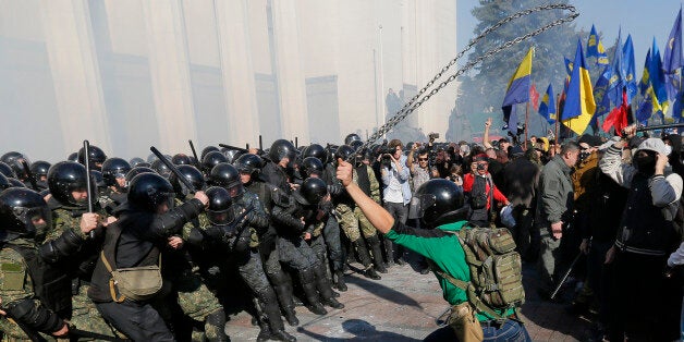 Police clash with rowdy demonstrators outside parliament in Kiev, Ukraine, on Tuesday, Oct. 14, 2014, as deputies repeatedly voted down proposals to officially recognize a contentious WWII-era partisan group as national heroes. Thousands of Svoboda nationalist party supporters rallied in Kiev earlier in the day in celebration of the Ukrainian Insurgent Army, but officials from the party denied vehemently that its members were involved in the unrest.(AP Photo/Sergei Chuzavkov)