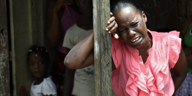 A woman reacts after a relative is suspected of dying from the Ebola virus, in the Liberian capital Monrovia, on October 4, 2014. By far the most deadly epidemic of Ebola on record has spread into five west African countries since the start of the year, infecting more than 7,000 people and killing about half of them. AFP PHOTO / PASCAL GUYOT. (Photo credit should read PASCAL GUYOT/AFP/Getty Images)