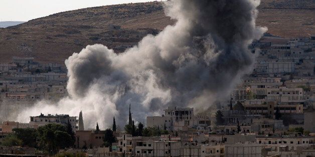 Thick smoke rises following an airstrike by the US-led coalition in Kobani, Syria while fighting continued between Syrian Kurds and the militants of Islamic State group, as seen from Mursitpinar on the outskirts of Suruc, at the Turkey-Syria border, Wednesday, Oct. 15, 2014. Kobani, also known as Ayn Arab, and its surrounding areas, has been under assault by extremists of the Islamic State group since mid-September and is being defended by Kurdish fighters. (AP Photo/Lefteris Pitarakis)