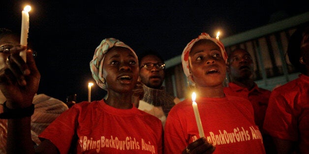 People hold candle light during a vigil to mark one month after the girls of government secondary school Chibok were kidnapped, in Abuja, Nigeria, Wednesday, May 14, 2014. Nigeria's government is ruling out an exchange of more than 270 kidnapped schoolgirls for detained Islamic militants, Britain's top official for Africa said Wednesday. Boko Haram abducted more than 300 schoolgirls from the school in Chibok in the northeastern state of Borno on April 15. (AP Photo/Sunday Alamba)