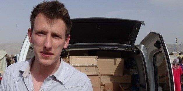 FILE - In this undated file photo provided by his family, Peter Kassig stands in front of a truck filled with supplies for Syrian refugees. The Indianapolis, Indiana, aid worker being held by the Islamic State group told family and teachers that heâd found his calling in 2012 when he decided to stay in the Middle East instead of returning to college, according to an email released Tuesday, Oct. 14, 2014 by his family. (AP Photo/Courtesy Kassig Family, File)