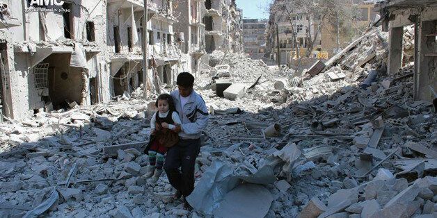 This photo provided by the anti-government activist group Aleppo Media Center (AMC), which has been authenticated based on its contents and other AP reporting, shows a Syrian man holding a girl as he stands on the rubble of houses that were destroyed by Syrian government forces air strikes in Aleppo, Syria, Monday, April 21, 2014. Syria will hold presidential elections on June 3, the country's parliament speaker announced Monday, a vote President Bashar Assad is likely to win, as the country enters its fourth year of war. (AP Photo/Aleppo Media Center AMC)