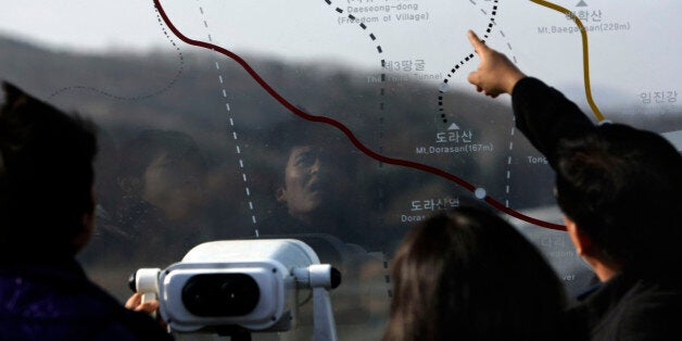 Visitors look at a map of the demilitarized zone at the Imjingak Pavilion near the border village of Panmunjom in Paju, South Korea, Wednesday, Dec. 22, 2010. South Korea vowed Wednesday to "punish the enemy" as hundreds of troops, fighter jets, tanks and attack helicopters prepared massive new drills near the heavily armed border a month after a deadly North Korean artillery attack. (AP Photo/Wally Santana)