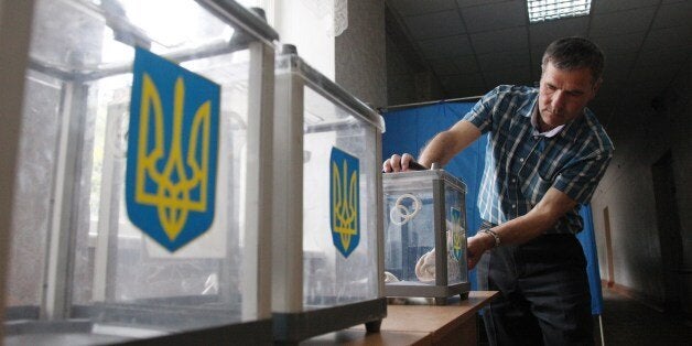 A member of the election commission prepares ballot boxes at one of the polling stations in Kiev on May 24, 2014, a day befor