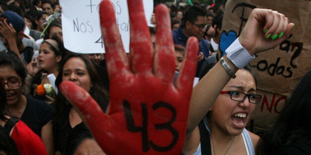 Demonstrators march in protest for the disappearance of 43 students from the Isidro Burgos rural teachers college, in Mexico City, Wednesday Oct. 22, 2014. Tens of thousands marched in Mexico City's main avenue demanding the return of the missing students. The Mexican government says it still does not know what happened to the young people after they were rounded up by local police in Iguala, a town in southern Mexico, and allegedly handed over to gunmen from a drug cartel Sept. 26, even though authorities have arrested 50 people allegedly involved. They include police officers and alleged members of the Guerreros Unidos cartel. (AP Photo/Marco Ugarte)