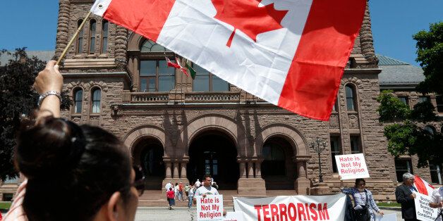 TORONTO, ON - JUNE 9: Haleema Sadia, of Burlington, holds up a Canadian flag during an anti-terrorism demonstration by progressive Muslims at Queen's Park. (Bernard Weil/Toronto Star via Getty Images)