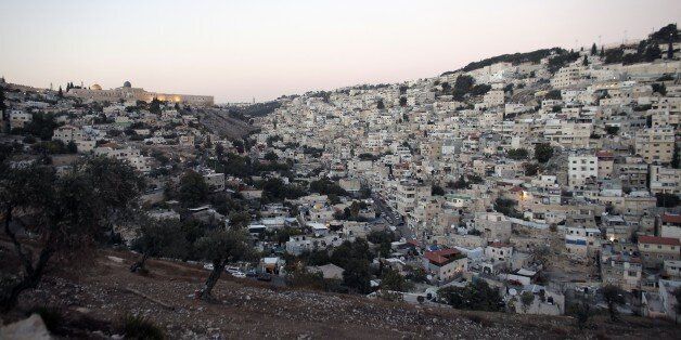 A picture taken on October 21, 2014 shows the Dome of the Rock in the Al-Aqsa mosque compound (L) and the east Jerusalem neighborhood of Silwan, a densely-populated Palestinian neighbourhood on a steep hillside flanking the southern walls of Jerusalem's Old City. By fair means or foul, Jewish settlers are notching up property gains in the heart of Arab east Jerusalem through a series of shady deals involving local frontmen or straw companies. Over the past three weeks, hardline settlers have moved into 35 apartments in the area, sparking anger and consternation among local Palestinians, who vehemently oppose such moves as a hostile attempt to Judaise the area. AFP PHOTO/AHMAD GHARABLI (Photo credit should read AHMAD GHARABLI/AFP/Getty Images)