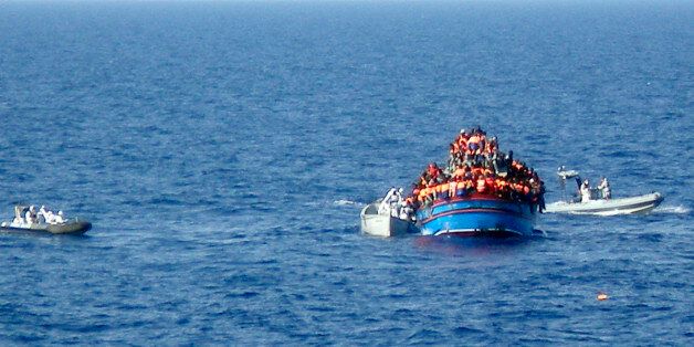 In this photo released by the Italian Navy on Monday, June 30, 2014, and taken on Sunday, June 29, 2014, motor boats from the Italian frigate Grecale approach a boat overcrowded with migrants in the Mediterranean Sea. The bodies of some 30 would-be migrants were found in in the hold of a packed smugglers' boat making its way to Italy, the Italian navy said Monday. The boat was carrying nearly 600 people, and the remaining 566 survivors were rescued by the navy frigate Grecale and were headed to the port at Pozzallo, on the southern tip of Sicily. (AP Photo/Italian Navy, ho)