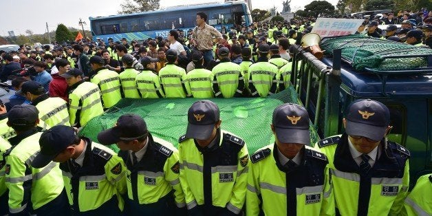 Policemen surround a truck carrying balloons and anti-North Korea leaflets after local residents blocked it near Imjingak peace park in the border city of Paju, north of Seoul, on October 25, 2014. Police intervened in a tense confrontation between residents of a South Korean border town and activists attempting to send propaganda leaflets into North Korea, preventing the launch which had prompted threats of retaliation from Pyongyang. AFP PHOTO / JUNG YEON-JE (Photo credit should read JUNG YEON-JE/AFP/Getty Images)