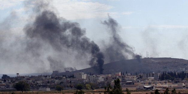 SANLIURFA, TURKEY - OCTOBER 26: Smoke rising in Kobani (Ayn al-Arab) during the clashes densified near Mursitpinar Border Crossing between Islamic State of Iraq and Levant (ISIL) members and armed groups, is seen from Suruc district of Turkey's Sanliurfa on October 26, 2014. (Photo by Ahmet Okatali/Anadolu Agency/Getty Images)
