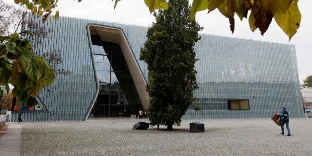 In this photo taken Tuesday, Oct. 21, 2014, a person walks outside the POLIN Museum of the History of Polish Jews in Warsaw, Poland. The museum, which opened in 2013 for temporary exhibitions and cultural programs, is holding the grand opening Tuesday, Oct. 28, 2014, for its core exhibition, the heart of the museum. The exhibition tells the 1,000 year history of Jews in Poland, from the Middle Ages until today. (AP Photo/Czarek Sokolowski)