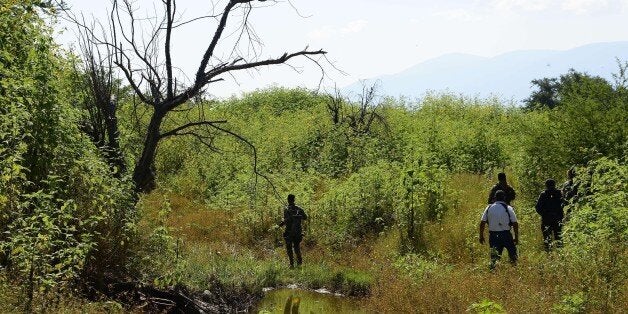 Members of the General Attorney's office and of the Mexican Navy search for human remains near a garbage-strewn hillside at Cocula Community, Guerrero State, Mexico on October 28, 2014. Mexican authorities have searched in vain for any trace of the college students who disappeared on September 26 in this town of some 140,000 inhabitants. Suspects arrested earlier this week told prosecutors that many of the 43 students from Iguala had been held near this location. AFP PHOTO/ALFREDO ESTRELLA (Photo credit should read ALFREDO ESTRELLA/AFP/Getty Images)