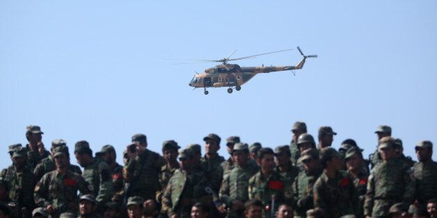 An Afghan National Army helicopter flies over soldiers during a military training exercise at Kabul Military Training Center, in Kabul, Afghanistan, Wednesday, Oct. 22, 2014. Taliban insurgents have stepped up their attacks against both Afghan and NATO security forces as most international security forces prepare to withdraw by the end of the year. (AP Photo/Massoud Hossaini)