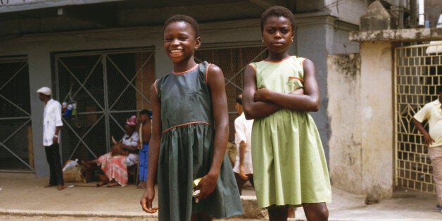 Two young girls pose for the camera along Fourah Bay Road in Freetown, Sierra Leone, March 1985 (Photo by Frances M. Ginter/Getty Images)