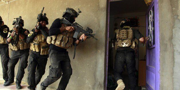 Iraqi special forces search a house in the Jurf al-Sakhr area, north of the Shiite shrine city of Karbala on October 30, 2014, after they retook the area from Islamic State (IS) group jihadists over the weekend after months of fighting the regain the ground. AFP PHOTO/HAIDAR HAMDANI (Photo credit should read HAIDAR HAMDANI/AFP/Getty Images)