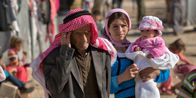 Syrian Kurdish refugees from the Kobani area walk at a camp in Suruc, near the Turkey-Syria border Monday, Nov. 3, 2014. Koba