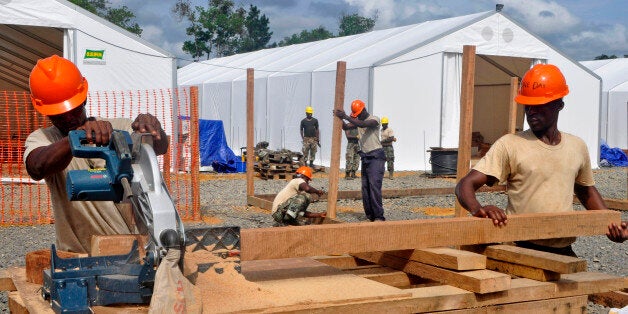 In this photo taken on Friday, Oct. 24, 2014, Liberian troops work to build a new section of an Ebola treatment center in the town of Tubmanburg, situated on the outskirts of the capital Monrovia, Liberia. More than 10,000 people have been infected with Ebola, according to figures released Saturday, Oct. 25, 2014 by the World Health Organization, as the outbreak continues to spread. Of those cases, 4,922 people have died. (AP Photo/Abbas Dulleh)