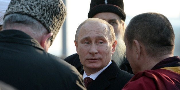 Russian President Vladimir Putin (C) speaks with confessional leaders during a ceremony at the Red square in Moscow on Novemb