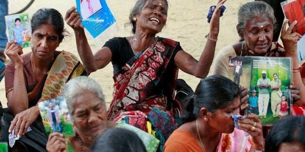 Sri Lankan ethnic Tamil women cry holding portraits of their missing relatives during a protest in Jaffna, Sri Lanka, Friday, Nov. 15, 2013. Hundreds of ethnic Tamils protested in the main northern city of Jaffna before British Prime Minister David Cameron's arrival, demanding answers about the thousands who went missing near the worst war's end in 2009 between soldiers and ethnic Tamil rebels fighting for a homeland. (AP Photo/Eranga Jayawardena)