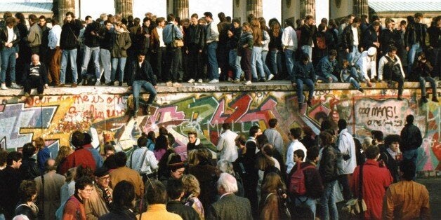 ** PACKAGE TO GO WITH THE 20TH ANNIVERSARY OF THE FALL OF THE BERLIN WALL ** FIFTEEN OF TWENTY ** FILE -- Germans from East and West stand on the Berlin Wall in front of the Brandenburg Gate in this Nov. 10, 1989, file photo, one day after the wall opened. Monday, Nov. 9, 2009 marks the 20th anniversary of the fall of the Berlin Wall. (AP Photo)