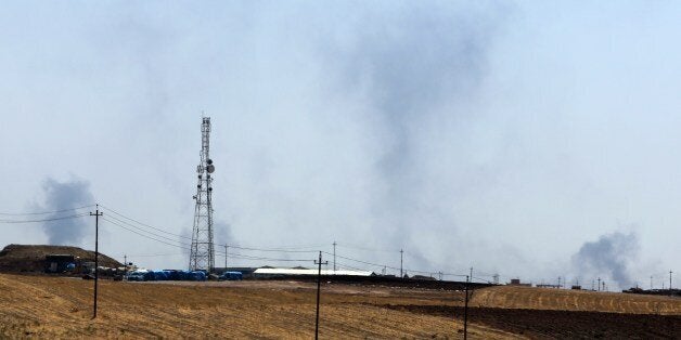 A picture taken on August 17, 2014 near the northern Iraqi city of Mosul shows smoke billowing after an US air strike near the Mosul dam, Iraq's largest, on the Tigris river. Iraqi Kurdish peshmerga forces backed by US air strikes retook the dam, situated about 50 kilometres (30 miles) north of Mosul, after jihadist militants seized it the previous week, officials said. AFP PHOTO/AHMAD AL-RUBAYE (Photo credit should read AHMAD AL-RUBAYE/AFP/Getty Images)