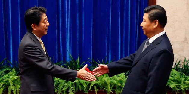 BEIJING, CHINA - NOVEMBER 10: Japan's Prime Minister Shinzo Abe shakes hands with China's President Xi Jinping (R), during th