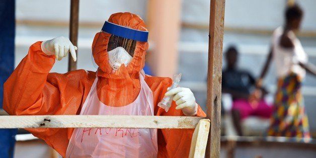 A health worker wearing a personal protective equipment works on November 11, 2014 in the red zone of the Hastings treatment center in Hastings, outside Freetown, the only run exclusively by locals. Some 1,130 people in the impoverished west African country have died from the virus out of 4,862 cases in the current outbreak, declared a state of emergency on July 31. Sierra Leone said on November 11 it was holding a journalist in a notorious prison because he had accused the government of provoking the kind of unrest seen in Burkina Faso through mismanagement of the Ebola crisis. Liberia has announced a dramatic drop in new Ebola infections as Mali prepared to lift quarantine restrictions on dozens of people put at risk of exposure to the deadly virus. AFP PHOTO/ FRANCISCO LEONG (Photo credit should read FRANCISCO LEONG/AFP/Getty Images)