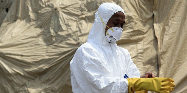 JAKARTA, INDONESIA - NOVEMBER 12: Indonesian health officials conduct simulation exercises for Ebola preparedness involving mock plane passengers during the Ministry of Health's 50th anniversary celebrations near the National Monument, Jakarta, Indonesia on November 12, 2014. The World Health Organization (WHO) on October 13 urged East Asian and Pacific countries to strengthen defenses against the Ebola outbreak, warning that the whole world may be at risk. The region of 1.8 billion has been a hotspot for many emerging diseases including Severe Acute Respiratory Syndrome and bird flu, but is so far free from the deadly Ebola virus ravaging part of West Africa. (Photo by Sagarmata/Anadolu Agency/Getty Images)