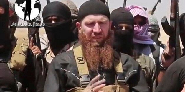This image made from undated video posted during the weekend of June 28, 2014 on a social media account frequently used for communications by the Islamic State of Iraq and the Levant (ISIL), which has been verified and is consistent with other AP reporting, shows Omar al-Shishani standing next to the group's spokesman among a group of fighters as they declare the elimination of the border between Iraq and Syria. Al-Shishani, one of hundreds of Chechens who have been among the toughest jihadi fighters in Syria, has emerged as the face of the Islamic State of Iraq and the Levant, appearing frequently in its online videos â in contrast to the group's Iraqi leader, Abu Bakr al-Baghdadi, who remains deep in hiding and has hardly ever been photographed. (AP Photo/militant social media account via AP video)