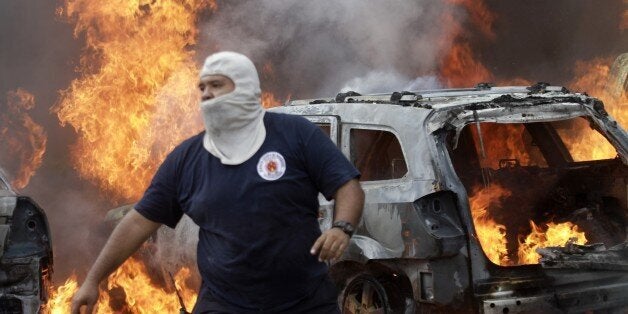 A firefighter is seen in front of vehicles set ablaze by protesters in Chilpancingo, Guerrero State, Mexico on November 12, 2014. Demonstrators angry over the disappearance of 43 college students set fire to the Guerrero state congress in southern Mexico on Wednesday in a new protest over the presumed massacre. AFP PHOTO/Pedro Pardo (Photo credit should read Pedro PARDO/AFP/Getty Images)