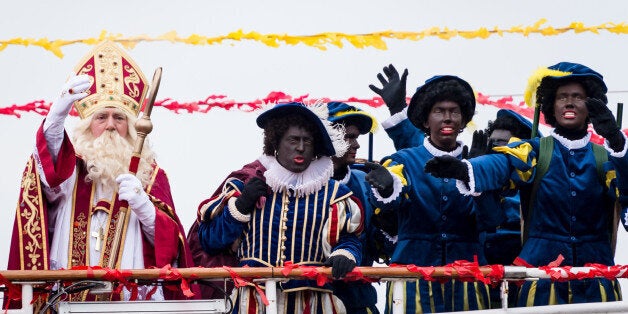 Actors dressed as Saint Nicolas, left, and Black Pete arrive on a boat in Antwerp, Belgium on Saturday, Nov. 15, 2014. Across the Netherlands and Belgium, celebrations in which Saint Nicholas rolls into town surrounded by a host of "Black Petes" have come under increasing pressure year by year from complaints about racism. (AP Photo/Geert Vanden Wijngaert)