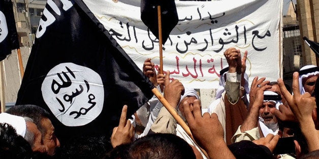 Demonstrators chant pro-al-Qaida-inspired Islamic State of Iraq and the Levant (ISIL) as they wave al-Qaida flags in front of the provincial government headquarters in Mosul, 225 miles (360 kilometers) northwest of Baghdad, Iraq, Monday, June 16, 2014. Sunni militants captured a key northern Iraqi town along the highway to Syria early on Monday, compounding the woes of Iraq's Shiite-led government a week after it lost a vast swath of territory to the insurgents in the country's north. (AP Photo)