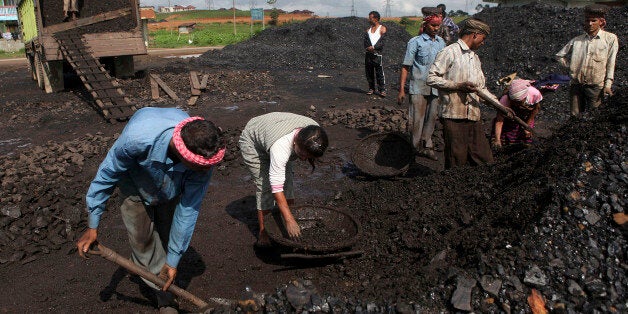 In this July 1, 2013 photo, Indian laborers dig a roadside coal depot at Khliehriet in Meghalaya, India. For six years in a r