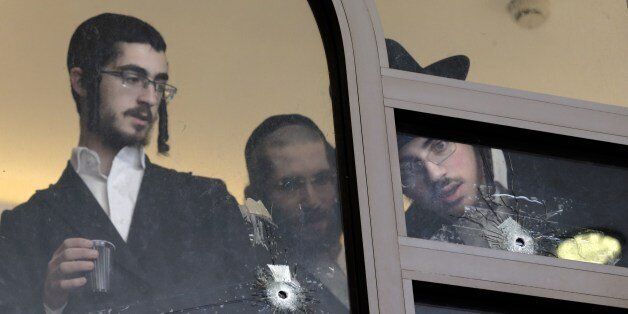Ultra Orthodox Jews look on November 19, 2014 at bullet holes in the main window of a synagogue in Jerusalem which was attacked the previous day by two Palestinians armed with a gun and meat cleavers leaving five Israeli worhipers killed. Israeli Prime Minister Benjamin Netanyahu vowed a harsh response to the bloodshed, and pledged to demolish the homes of the perpetrators in line with a policy announced earlier this month. AFP PHOTO / THOMAS COEX (Photo credit should read THOMAS COEX/AFP/Getty Images)
