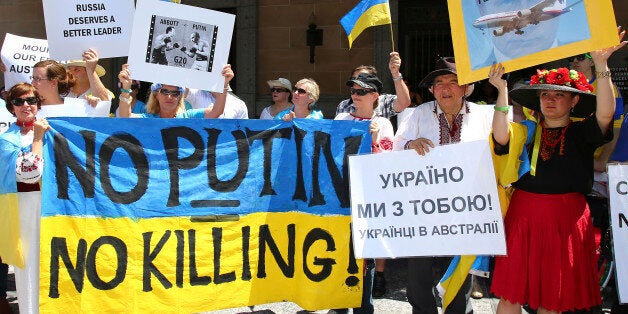 Anti-Russian protesters hold banners at a rally during the G-20 in Brisbane, Australia, Saturday, Nov. 15, 2014. The protesters staged the rally against the downing of Malaysia Airlines Flight MH17 over eastern Ukraine on July 17 this year. (AP Photo/Tertius Pickard)