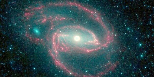 The galaxy, called NGC 1097, is located 50 million light-years away. It is spiral-shaped like our Milky Way, with long, spindly arms of stars. The 'eye' at the center of the galaxy is a black hole surrounded by a ring of stars. Spitzer. (Photo by: Universal History Archive/UIG via Getty Images)