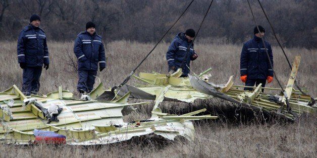 DONETSK, UKRAINE - NOVEMBER 18: Workers remove parts of the wreckage of Malaysia Airlines passenger jet MH17 at the helm of Dutch investigators and members of OSCE Special Monitoring Mission at the crash site in rebel-held Grabovo village, about 70 km from Donetsk, Ukraine on November 18, 2014. The Malaysian Airlines plane, which was flying from Amsterdam to Kuala Lumpur, was shot down over Ukraine in July. (Photo by Alexander Ermochenko/Anadolu Agency/Getty Images)