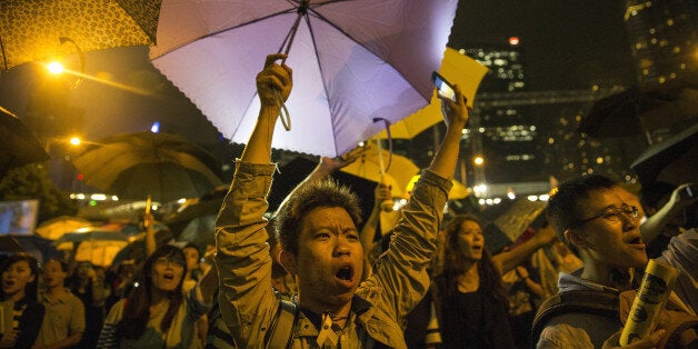 HONG KONG - OCTOBER 29: Umbrellas are opened as tens of thousands come to the main protest site one month after the Hong Kong police used tear gas to disperse protesters October 29, 2014 in Hong Kong, Hong Kong. A peaceful safe atmosphere remains at the massive protest site as artists freely express themselves and families bring their children to experience the Umbrella Revolution. (Photo by Paula Bronstein/Getty Images)