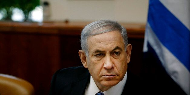 Israel's Prime Minister Benjamin Netanyahu chairs the weekly cabinet meeting in Jerusalem, Sunday, Nov. 30, 2014. Israel's prime minister said Sunday that the public expects the government to "return to normal conduct" and hinted at the possibility of early elections if his coalition does not overcome a crisis linked to a contentious nationality bill that would enshrine Israel's status as a Jewish state. The proposal would also make Jewish law a source of legislative inspiration and delist Arabic as an official language. (AP Photo/Ronen Zvulun, Pool)
