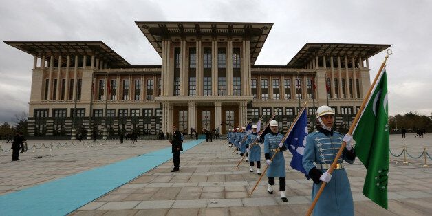 Military honour guard walk outside the main building of the new Presidential Palace complex after a welcome ceremony for Russian President Vladimir Putin in Ankara, Turkey, Monday, Dec. 1, 2014. Putin arrived in Turkey for a one-day visit and met with Erdogan at his huge new palace on once-protected farm land and forest in Ankara, becoming the second foreign dignitary after the Pope Francis to be hosted at the lavish, 1000-room complex.(AP Photo/Burhan Ozbilici)