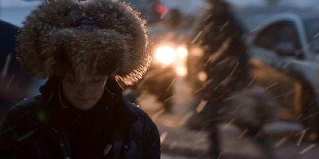 A man walks along a street in central Moscow during a snowfall on December 10, 2014. AFP PHOTO / KIRILL KUDRYAVTSEV (P