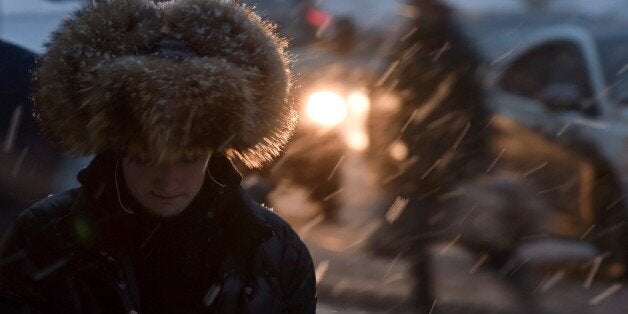 A man walks along a street in central Moscow during a snowfall on December 10, 2014. AFP PHOTO / KIRILL KUDRYAVTSEV (Photo credit should read KIRILL KUDRYAVTSEV/AFP/Getty Images)