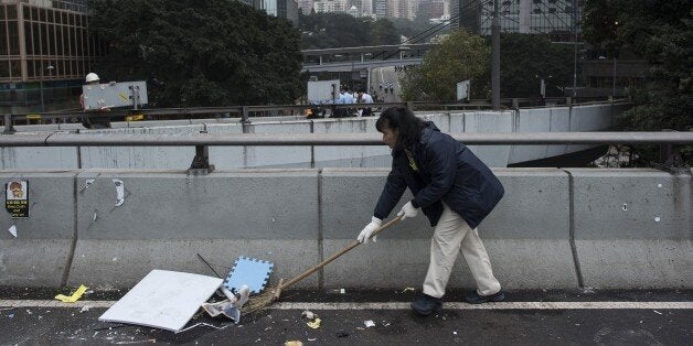 A worker cleans the street after Hong Kong police dismantled the main pro-democracy protest camp in the Admiralty district of