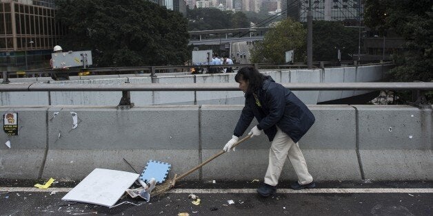 A worker cleans the street after Hong Kong police dismantled the main pro-democracy protest camp in the Admiralty district of Hong Kong on December 11, 2014. Hong Kong police began dismantling the city's main pro-democracy site on December 11, clearing away tents and barricades after more than two months of rallies, and hauling off a hard core of protesters who nevertheless vow that their struggle lives on. AFP PHOTO / PEDRO UGARTE (Photo credit should read PEDRO UGARTE/AFP/Getty Images)